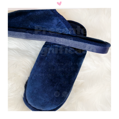 Chinelos azuis escuros aveludados sobre fundo felpudo branco