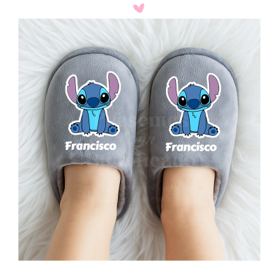 Chinelos cinzentos com personagem azul e texto Francisco, sobre tapete branco