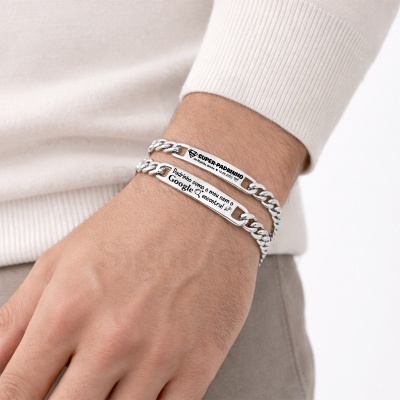 Duas pulseiras de corrente metálica prateada com placas gravadas no pulso