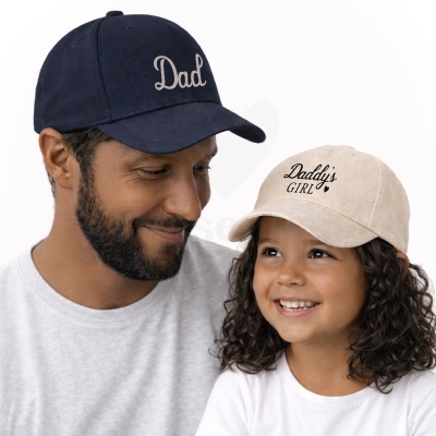 Homem e criança com bonés temáticos Dad e Daddys Girl