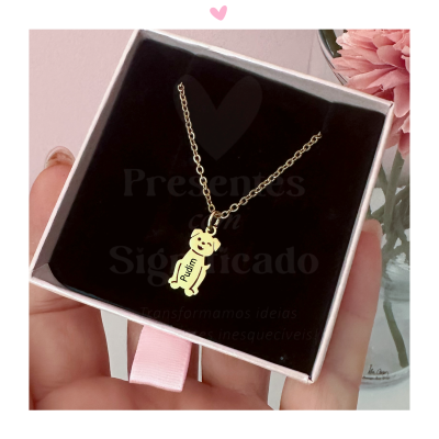 Colar dourado com pendente de urso 'Pufin' em caixa com interior preto e fita rosa