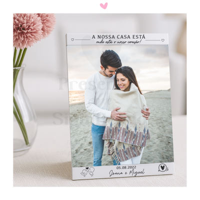 Fotografia de casal na praia impressa num suporte branco com texto e data personalizadas.