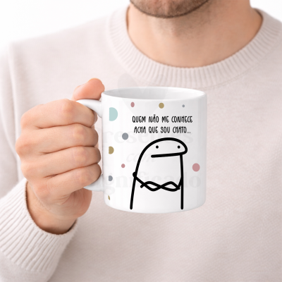 Caneca branca com ilustração e texto em português, segurada por uma mão.