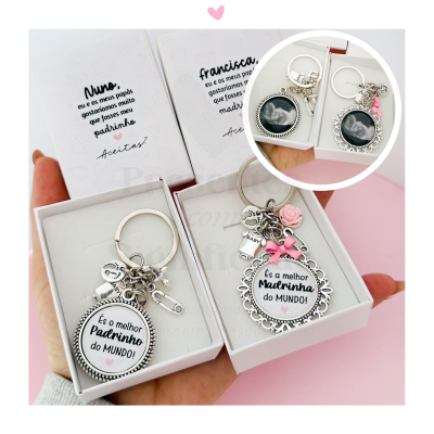 Porta-chaves prateado com medalhão e texto em português em caixas brancas