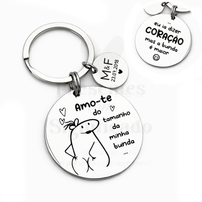 Chaveiro metálico redondo com texto e desenho humorístico.