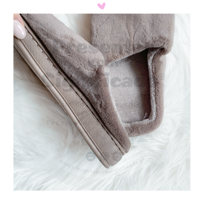 Pantufas felpudas castanho claro com sola castanha sobre superfície branca macia