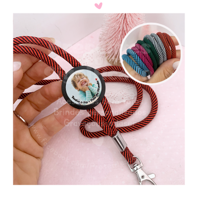 Cordão vermelho e preto com botão circular personalizado e mosquetão, braceletes coloridas ao fundo