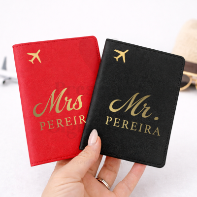 Porta-passaportes vermelho Mrs PEREIRA e preto Mr. PEREIRA com símbolo de avião dourado.