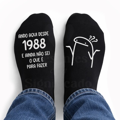 Meias pretas com texto e desenho branco usadas com jeans.