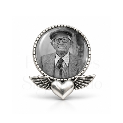 Medalhão redondo de metal com coração alado e foto preto e branco de homem idoso
