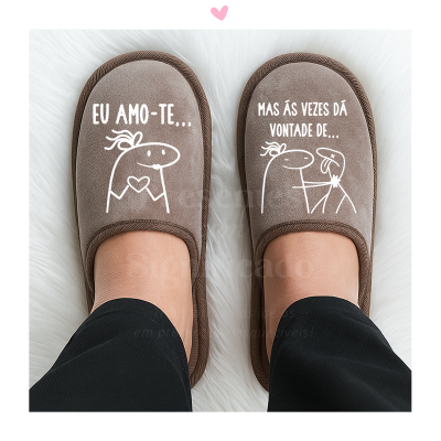 Chinelos castanhos com frases e desenhos em branco, usados em superfície branca.