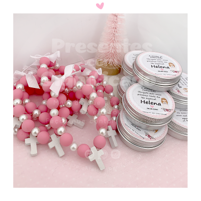 Pulseiras ou colares rosas com pérolas e cruzes brancas junto com latas de metal etiquetadas HELENA