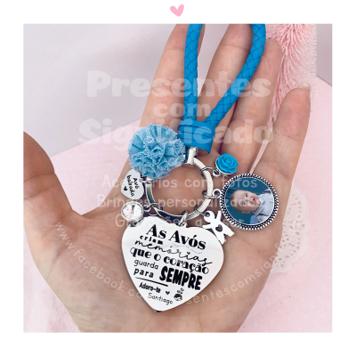 Chaveiro com pendentes metálicos e cordão azul trançado com frase em português e foto de bebé
