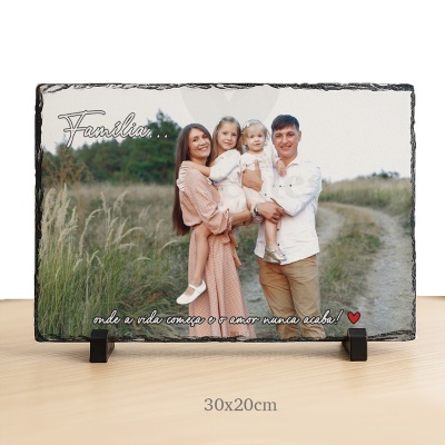 Placa em pedra com foto de família e texto em português sobre fundo natural