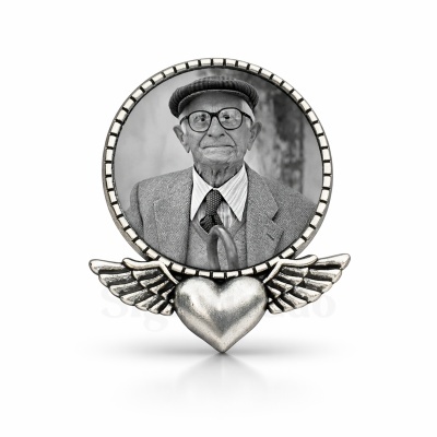 Moldura redonda de metal prateado com coração e asas abaixo, com foto preto e branco de homem idoso.
