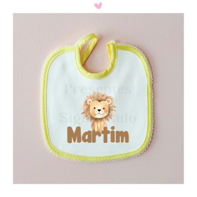 Babete branco com borda amarela, leão sorridente e nome Martim