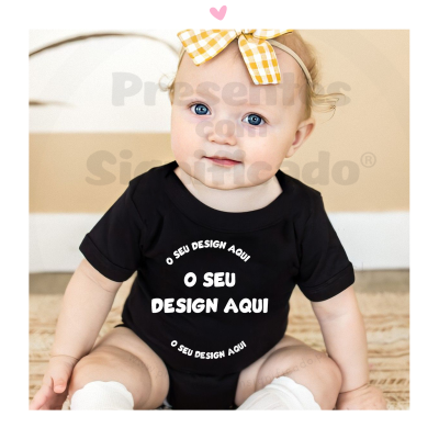 Bebé com body preto e laço amarelo sentada no chão