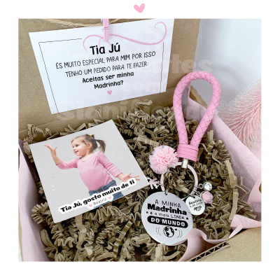 Conjunto de oferta para madrinha com porta-chaves rosa, pendente prateado, fotografia de criança e cartão com mensagem em português