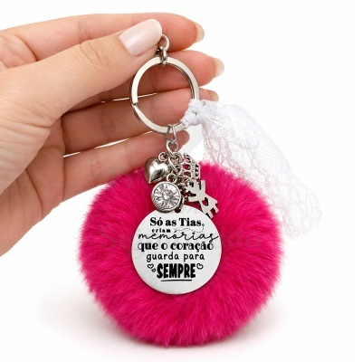 Chaveiro com pompom rosa e pingentes metálicos com texto