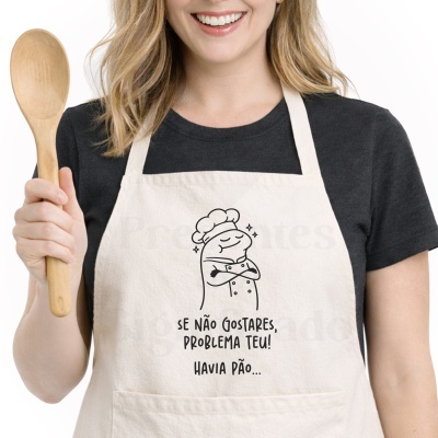 Avental bege com desenho de cozinheiro e frase em português, mulher segurando colher de pau