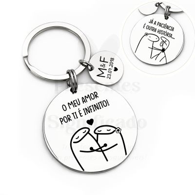 Chaveiro metálico com duas placas redondas gravadas com texto e ilustrações simples em fundo branco.