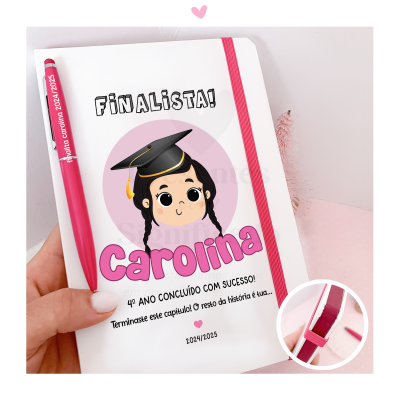 Caderno branco com ilustração e texto de finalista, caneta rosa e elástico rosa