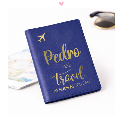 Capa de passaporte azul com texto dourado e desenhos, sobre superfície branca com mapa e óculos ao lado.