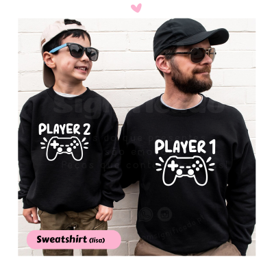 Duas pessoas com sweatshirts pretas e gravuras brancas de comandos de videojogos PLAYER 1 e PLAYER 2