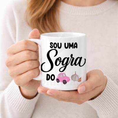 Caneca branca com texto e imagens, segurada por mãos de pessoa com camisola branca.