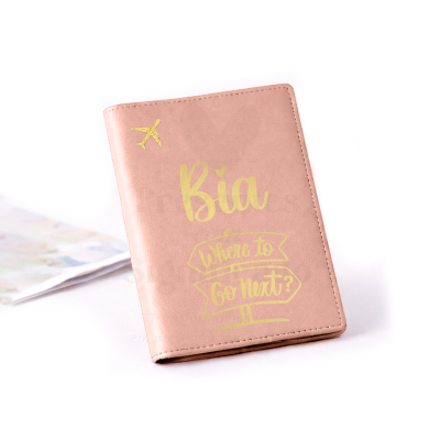 Capa de passaporte cor de rosa com texto e avião dourados