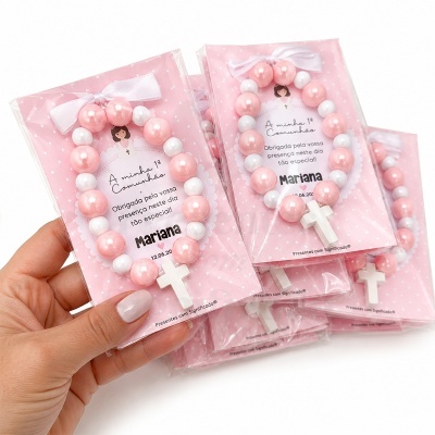 Pulseira para primeira comunhão rosa e branca em embalagem cor-de-rosa com estrelas e texto