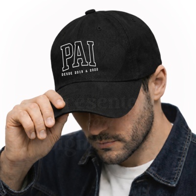 Homem a usar boné preto com a palavra PAI e texto branco