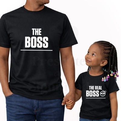 Duas t-shirts pretas com texto branco THE BOSS e THE REAL BOSS, adulto e criança de mãos dadas.