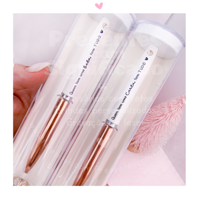 Dois canetas metalizadas cobre com tampa branca e texto em português numa embalagem transparente