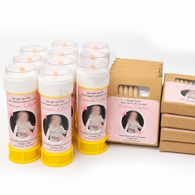 Produtos para batizado Maria Clara com tubos plásticos amarelos e caixas de lápis de cartão castanho com etiquetas cor-de-rosa