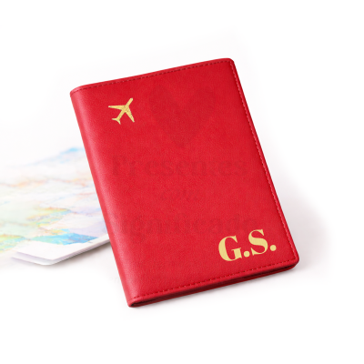 Porta-passaporte vermelho com avião dourado e iniciais G.S.