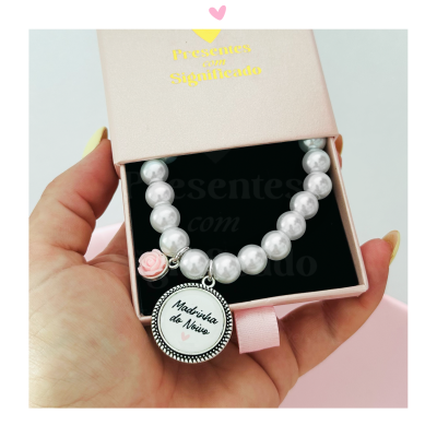 Pulseira de contas peroladas brancas com pingente e flor rosa em caixa cor-de-rosa