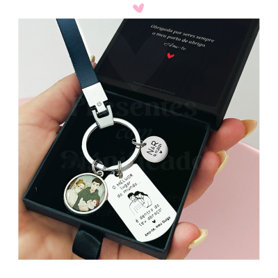 Chaveiro com pendentes e texto dentro de caixa preta