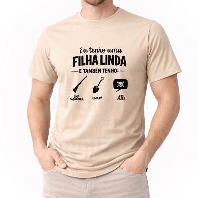 T-shirt bege com texto e ícones pretos, pessoa com mãos nos bolsos.