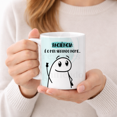 Caneca branca com texto e desenho segurada por duas mãos