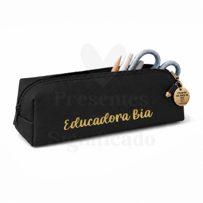 Estojo preto com fecho e texto dourado Educadora Bia e pendente redondo dourado com texto e canetas dentro