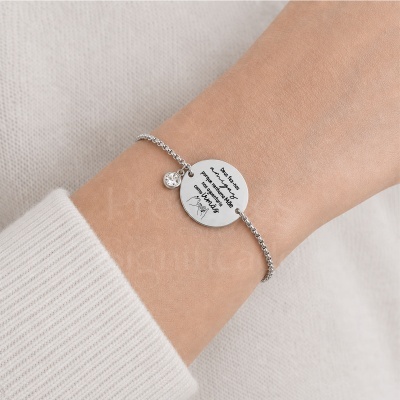 Pulseira prata com medalha gravada e pendente de cristal no pulso