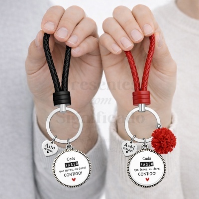 Dois porta-chaves com alças trançadas em preto e vermelho, pendentes com texto e um coração pequeno, um com pompom vermelho.