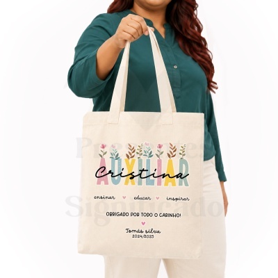 Mala tote de algodão com decoração floral e texto personalizado, segurada por mulher com camisa verde