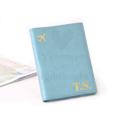 Porta-passaporte azul com avião e iniciais douradas