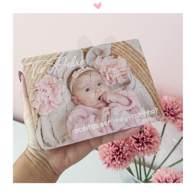Puzzle de madeira com foto de bebé e texto personalizado em mão diante de flores cor-de-rosa