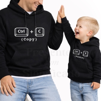 Duas pessoas com sweatshirts pretas com estampa de teclas de computador e calças de ganga em fundo branco.