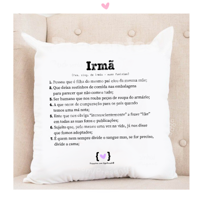 Almofada branca com texto humorístico sobre irmãs num sofá castanho claro