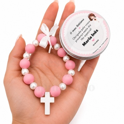 Pulseira rosa e pérola com cruz branca e lata de batismo em mão