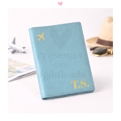 Capa para passaporte azul com avião dourado e iniciais T.S.